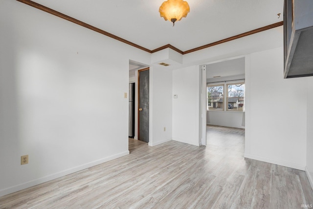 unfurnished room featuring light wood-type flooring, visible vents, crown molding, and baseboards