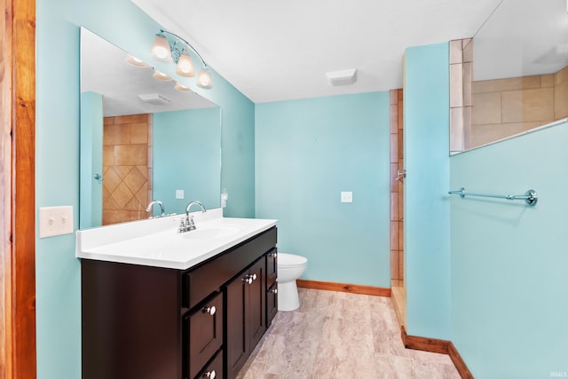 bathroom featuring vanity, toilet, and baseboards