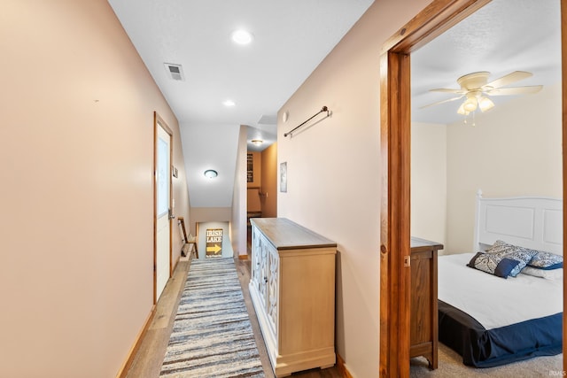 corridor with recessed lighting, wood finished floors, visible vents, and baseboards