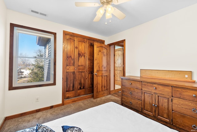 carpeted bedroom featuring a closet, visible vents, ceiling fan, and baseboards