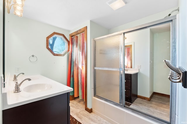 bathroom with double vanity, visible vents, a stall shower, a sink, and baseboards