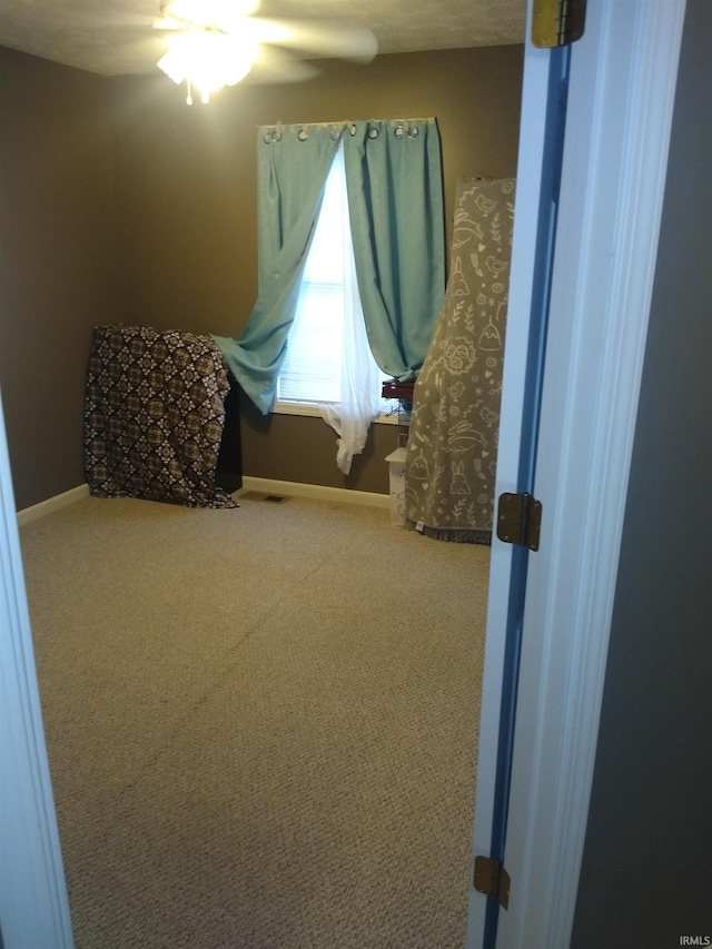 carpeted bedroom with a ceiling fan and baseboards