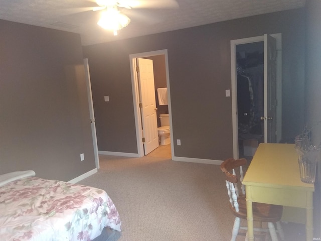 carpeted bedroom featuring a walk in closet, a closet, connected bathroom, and baseboards