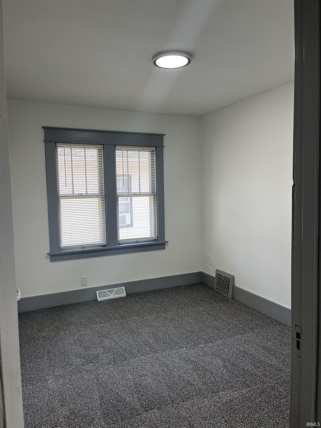 spare room featuring carpet flooring, visible vents, and baseboards