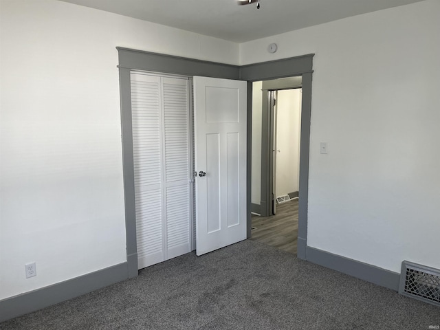 unfurnished bedroom with carpet floors, a closet, visible vents, and baseboards