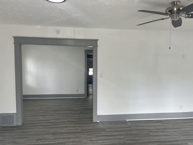 empty room featuring visible vents, a textured ceiling, and wood finished floors