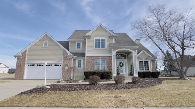 traditional home with driveway, roof with shingles, a chimney, and brick siding