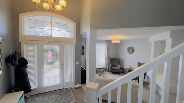 entryway featuring a chandelier, a high ceiling, and stairs