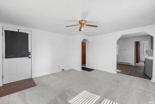 unfurnished living room with visible vents, arched walkways, baseboards, baseboard heating, and carpet floors