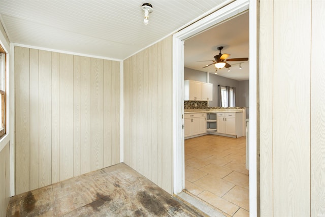 spare room featuring a ceiling fan and wooden walls