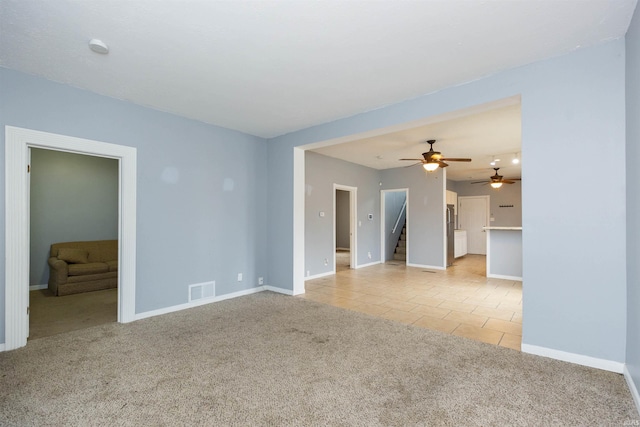 unfurnished room with visible vents, baseboards, light colored carpet, stairway, and light tile patterned flooring