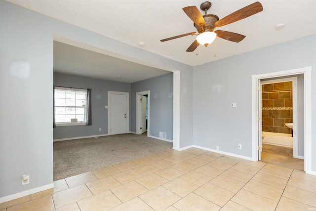 spare room featuring visible vents, baseboards, ceiling fan, and light tile patterned flooring