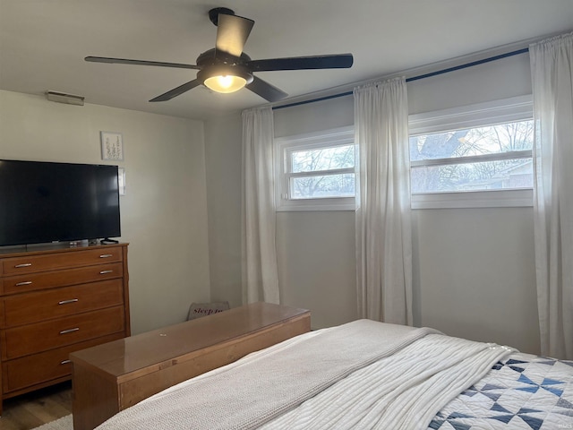 bedroom with visible vents, wood finished floors, and a ceiling fan