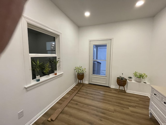 doorway to outside featuring baseboards, dark wood-style flooring, and recessed lighting