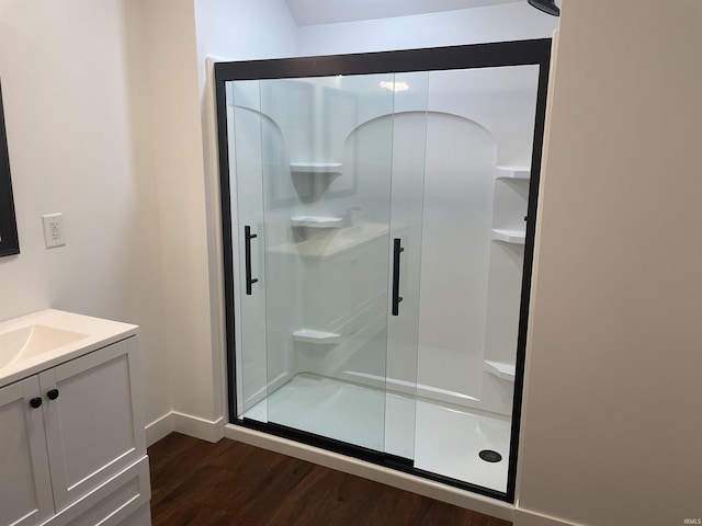 full bath featuring baseboards, a shower stall, vanity, and wood finished floors