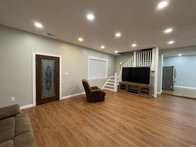 living room with recessed lighting, stairway, and light wood finished floors