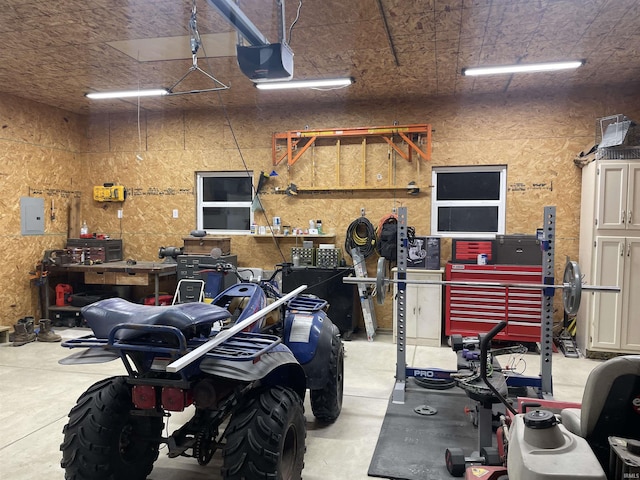 garage featuring a workshop area, electric panel, and a garage door opener