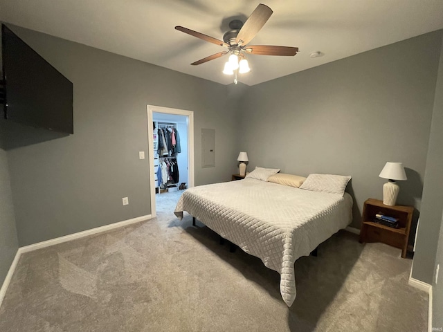 bedroom with baseboards, ceiling fan, a walk in closet, carpet floors, and a closet