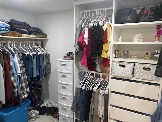 walk in closet featuring water heater and carpet flooring