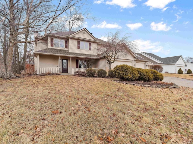 traditional home featuring an attached garage, covered porch, and a front lawn