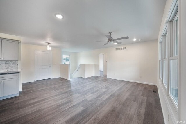 unfurnished living room featuring dark wood-style flooring, recessed lighting, visible vents, and baseboards