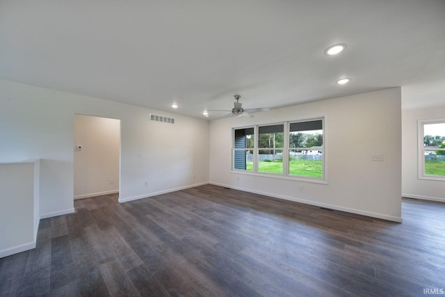 spare room featuring baseboards, visible vents, and dark wood finished floors