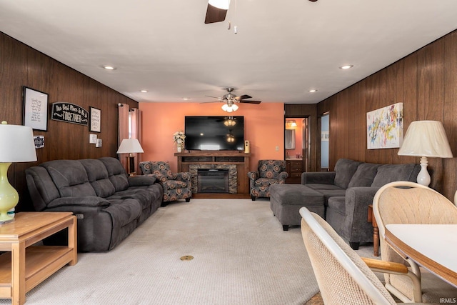 living room with light carpet, wood walls, and ceiling fan