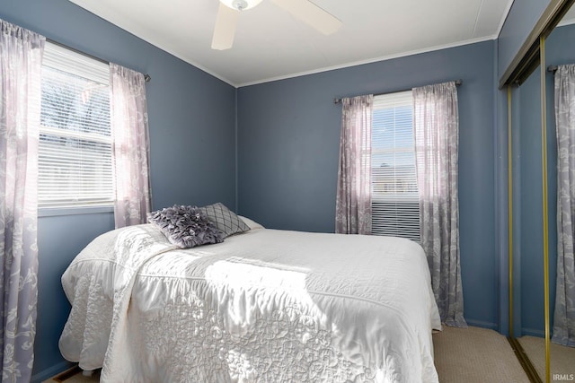 bedroom with carpet floors, multiple windows, and ornamental molding