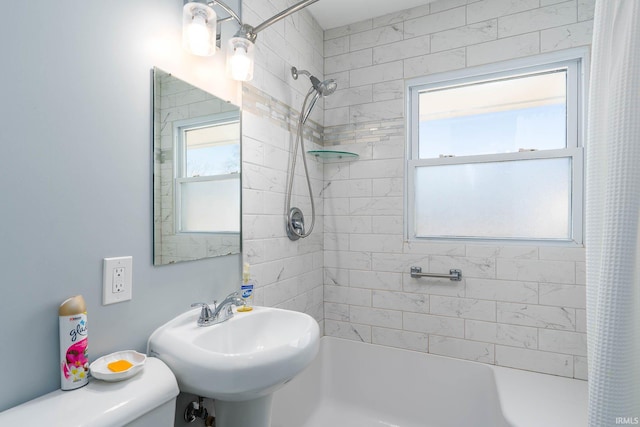 full bathroom with a sink, shower / bathtub combination with curtain, and toilet