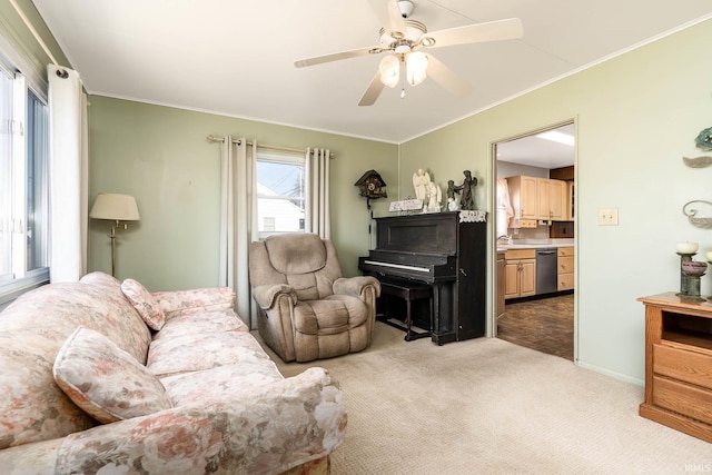 carpeted living room featuring baseboards, a ceiling fan, and crown molding