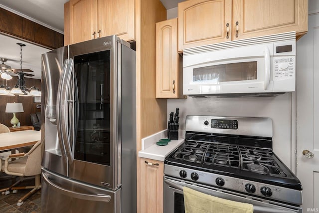 kitchen featuring light countertops, appliances with stainless steel finishes, light brown cabinets, and a ceiling fan