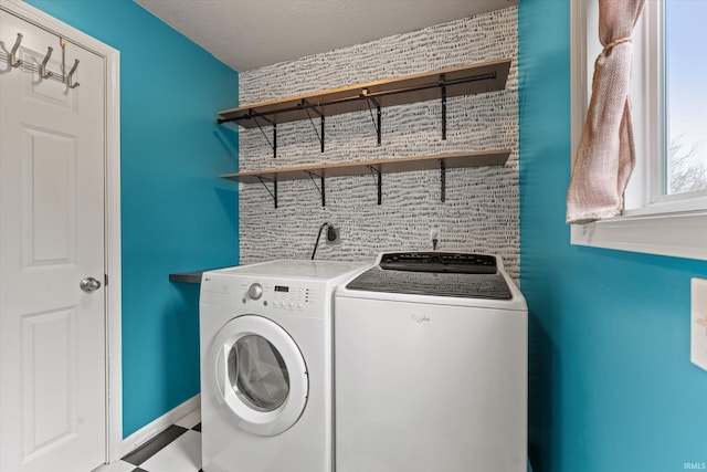 clothes washing area with laundry area, washer and clothes dryer, and baseboards