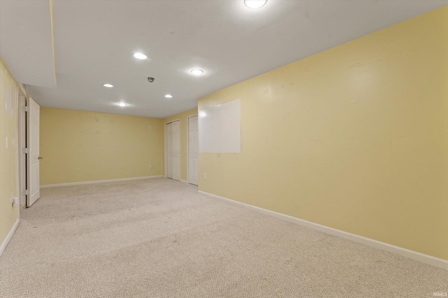 unfurnished room with baseboards, recessed lighting, and light colored carpet