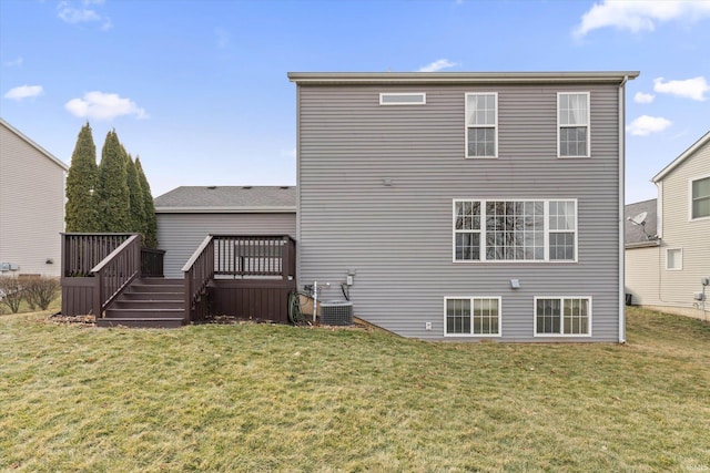 rear view of house featuring a lawn and a wooden deck