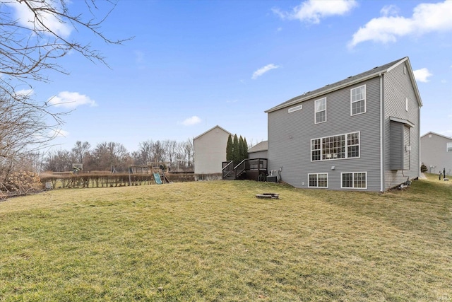 back of property with a yard and a playground