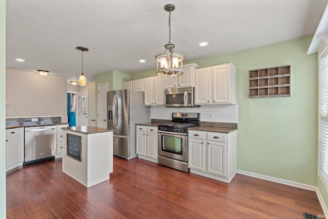 kitchen featuring decorative backsplash, appliances with stainless steel finishes, dark wood-style flooring, decorative light fixtures, and a center island