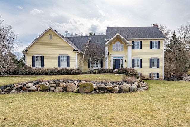 view of front of home featuring a chimney and a front lawn