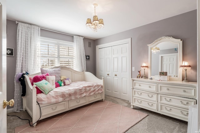 bedroom featuring a closet, light colored carpet, and a notable chandelier