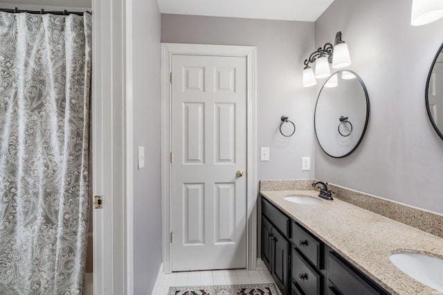 bathroom with double vanity, a sink, and tile patterned floors