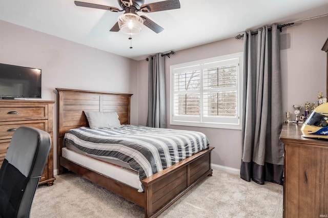 bedroom featuring light carpet, ceiling fan, and baseboards