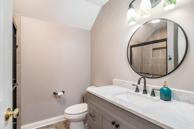 bathroom with toilet, wood finished floors, vanity, baseboards, and tiled shower