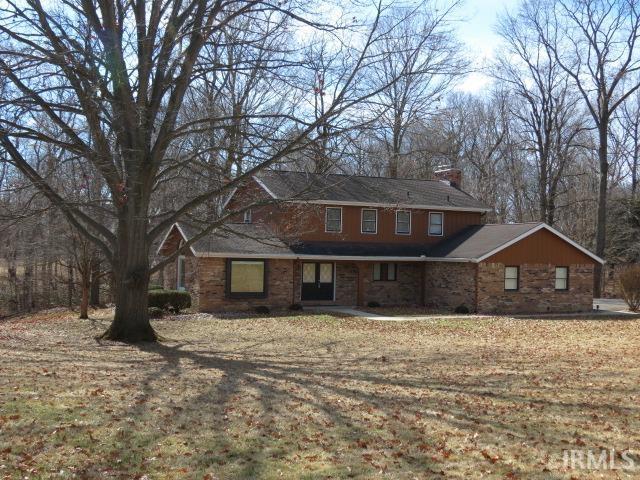 traditional home with stone siding and a chimney