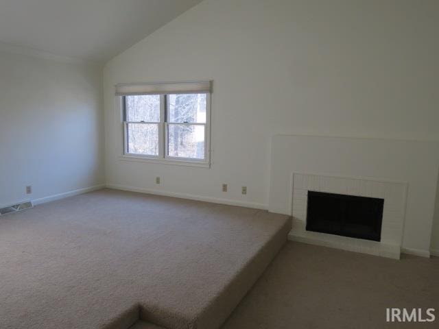 unfurnished living room with carpet floors, a fireplace, lofted ceiling, visible vents, and baseboards