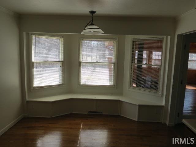 unfurnished dining area with a wealth of natural light and dark wood-style flooring