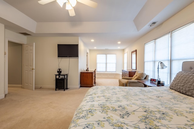 bedroom with a tray ceiling, light carpet, baseboards, and recessed lighting