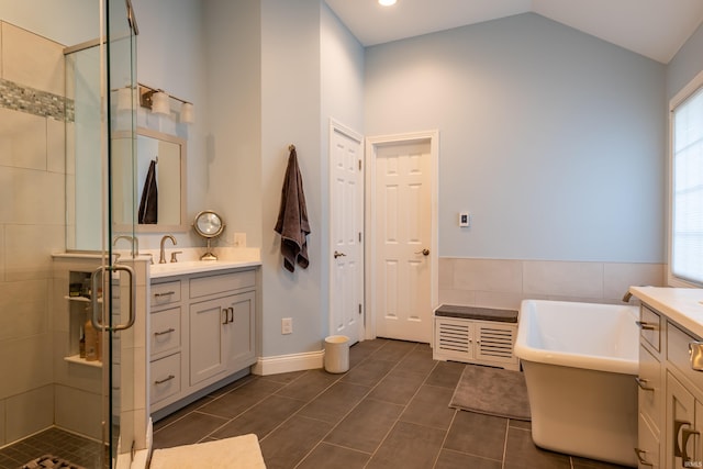 full bath with a freestanding bath, a shower stall, and vanity