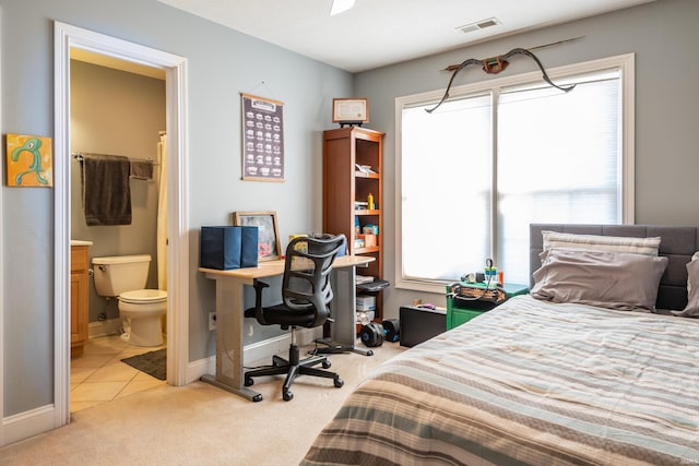 carpeted bedroom with multiple windows, visible vents, baseboards, and ensuite bathroom