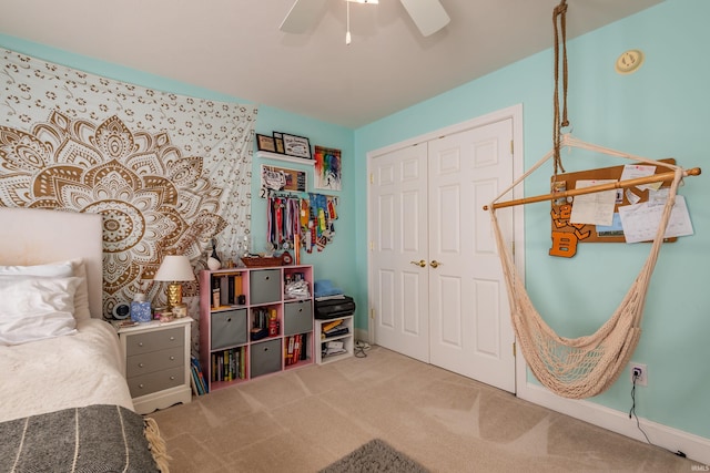 carpeted bedroom with ceiling fan, baseboards, and a closet