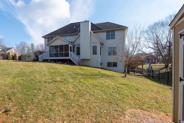 rear view of property with a yard, a fenced backyard, and a sunroom