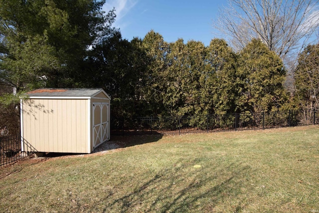 view of yard featuring fence, a storage unit, and an outbuilding